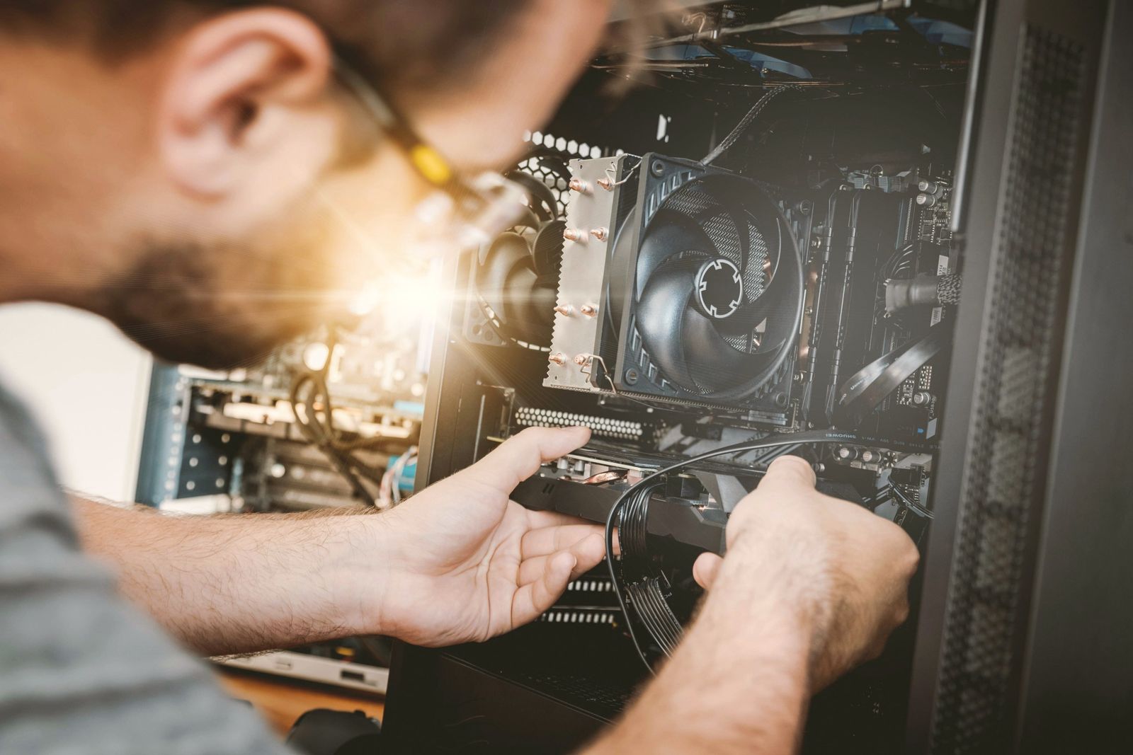 Technician installing a component inside a desktop computer